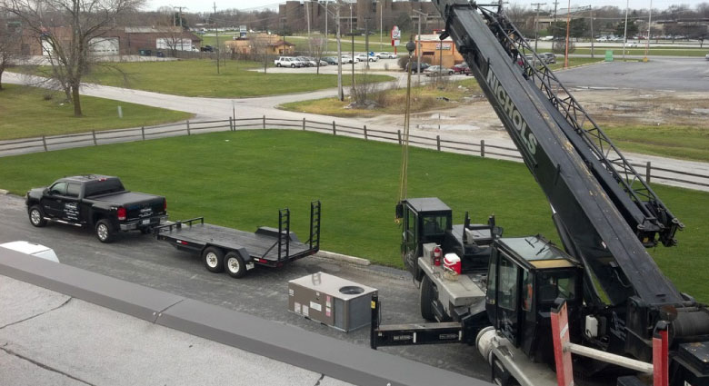 Hoisting a new Rooftop unit into place.